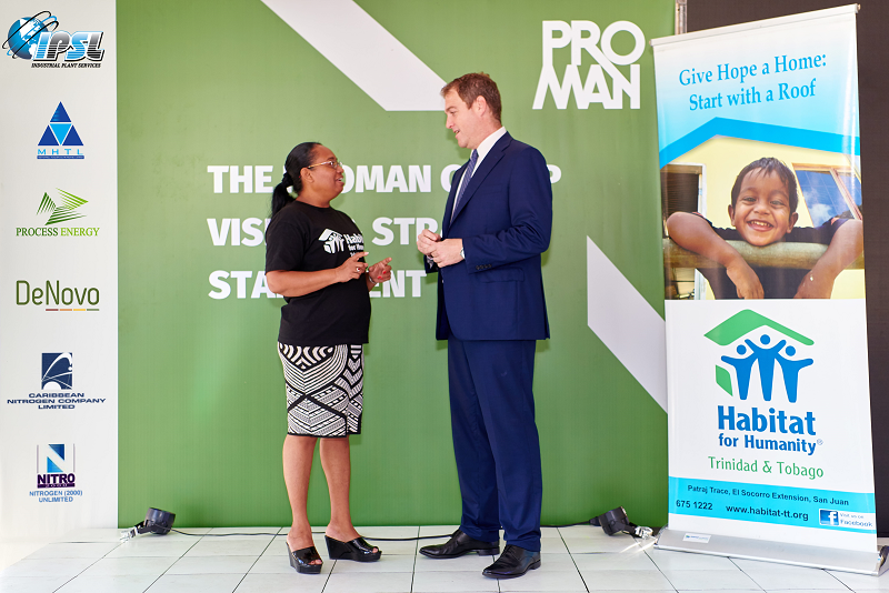 Photo of Proman Chief Executive David Cassidy (middle-aged Caucasian man dressed in blue business suit) and Habitat Trinidad-Tobago National Director Jennifer Massiah (middle-aged mixed race woman dressed in Habitat Trinidad-Tobago teeshirt and black-and-white patterned skirt) in discussion at the formal announcement